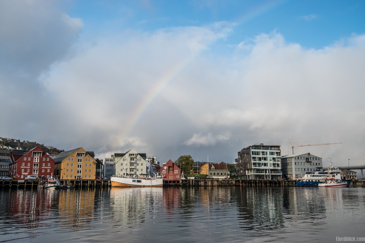 Nach dem Regenschauer ist ein Regenbogen im Hafen Tromsøs zu sehen
